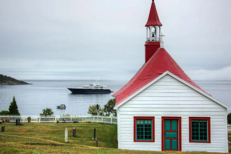 a red and white building by a body of water aboard ARCHIMEDES Yacht for Sale