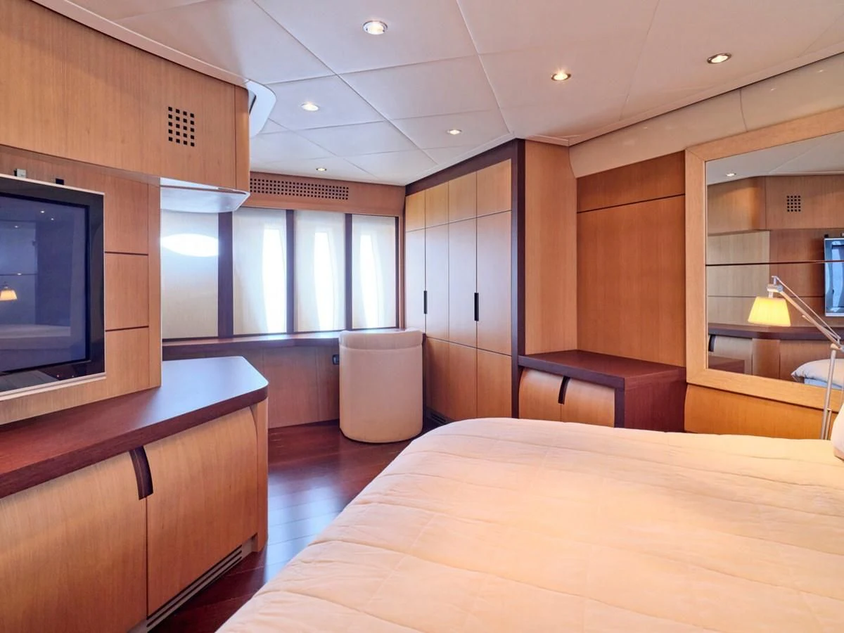 a room with a bed and a tv aboard ONE Yacht for Charter
