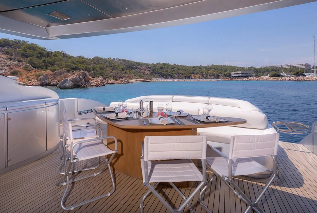 a table and chairs on a deck overlooking a body of water aboard ONE Yacht for Charter