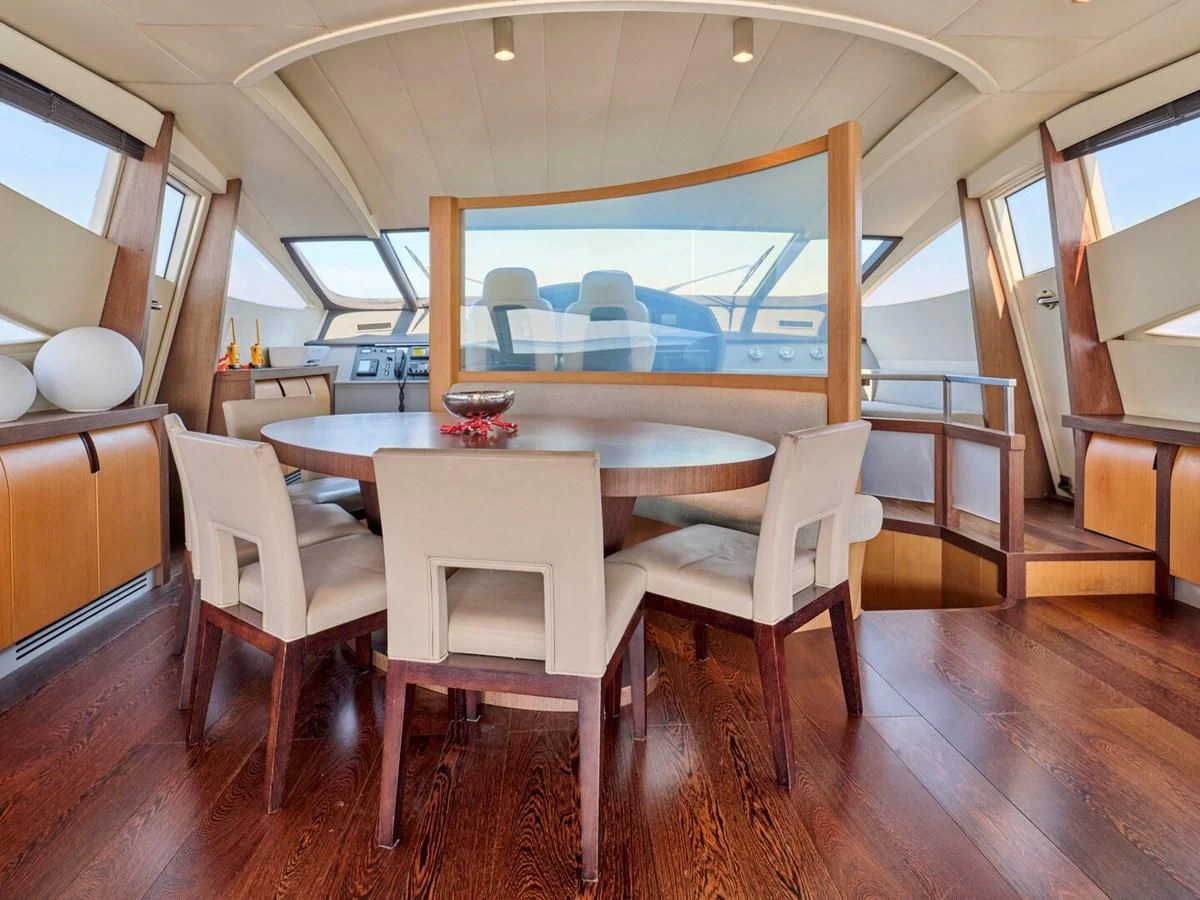 a room with a table chairs and a large fish tank aboard ONE Yacht for Charter