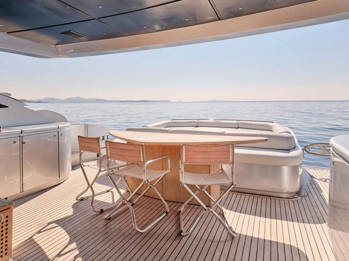 a table and chairs on a deck aboard ONE Yacht for Charter