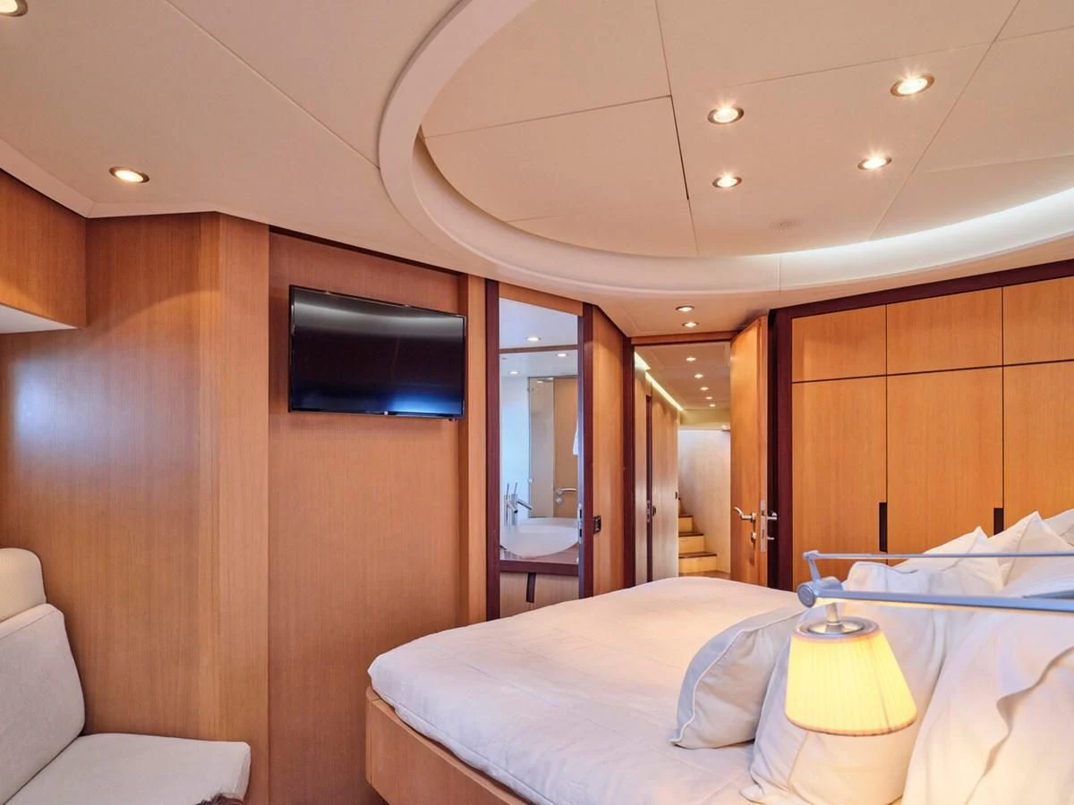 a hotel room with a bed and tv aboard ONE Yacht for Charter