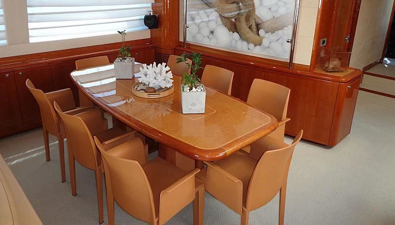 a table with chairs and a vase of flowers on it aboard ASTARTE Yacht for Sale