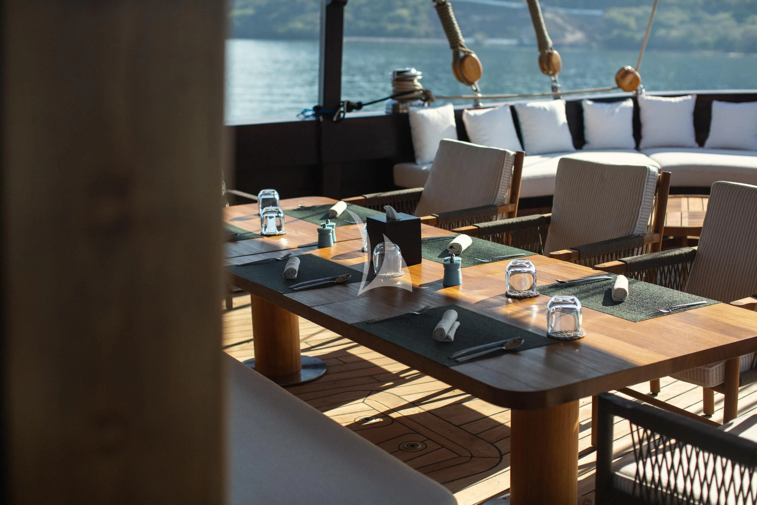 a table with chairs and a window aboard VELA Yacht for Charter