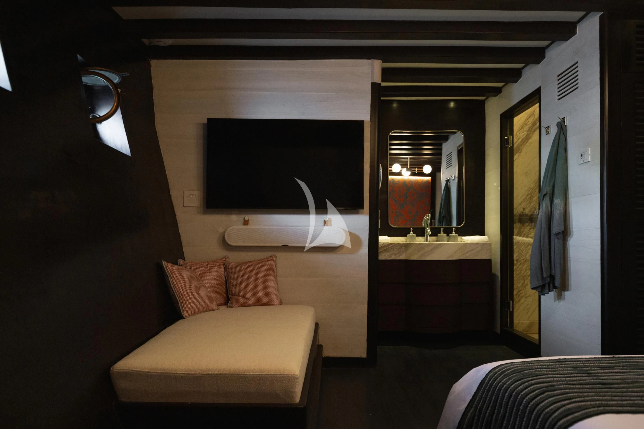 a room with a bed and a television aboard VELA Yacht for Charter