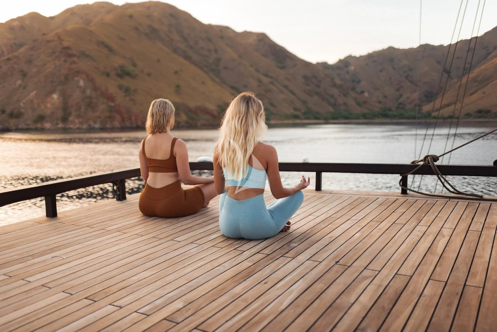 two women sitting on a dock aboard VELA Yacht for Charter