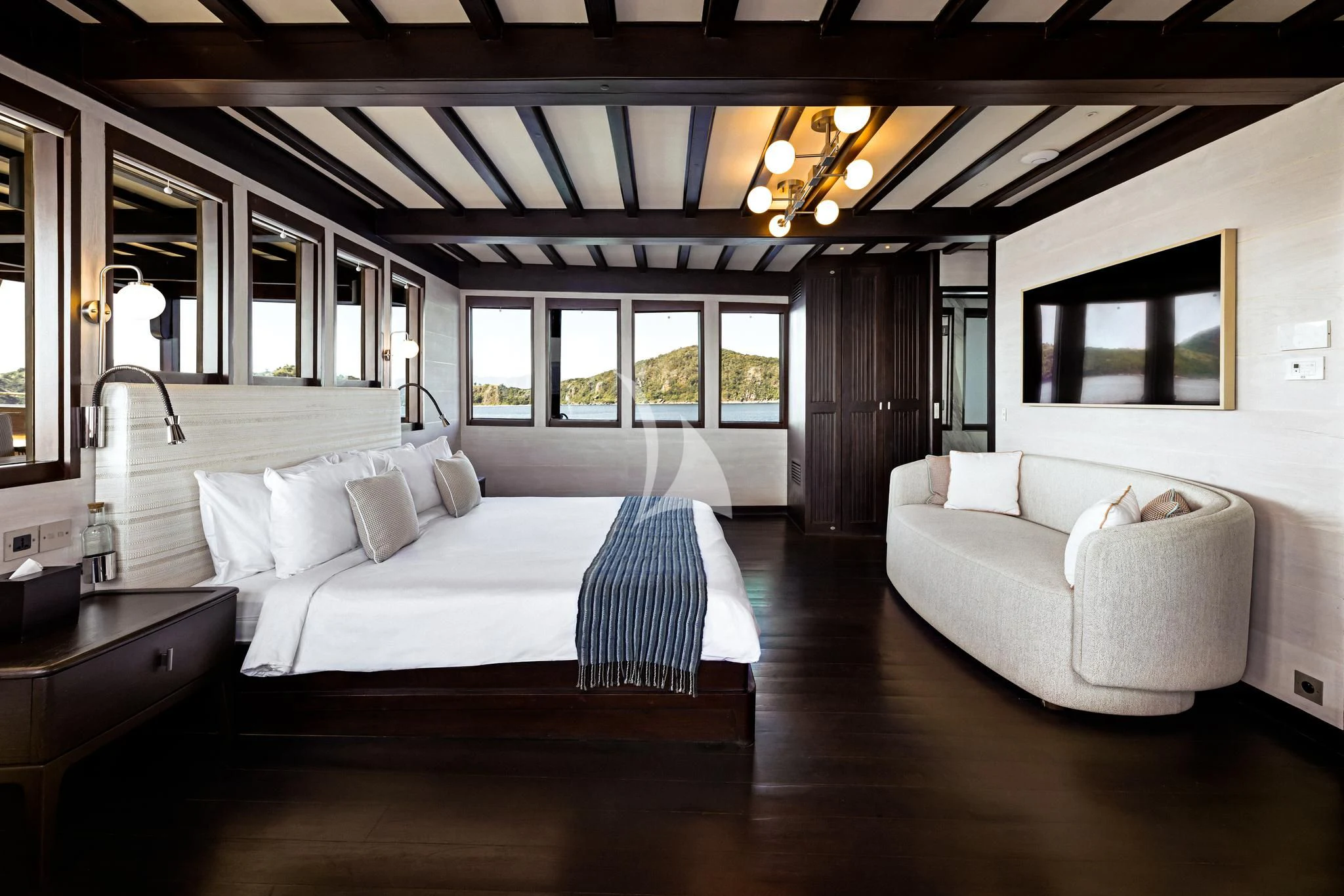 a room with a bed and a couch aboard VELA Yacht for Charter