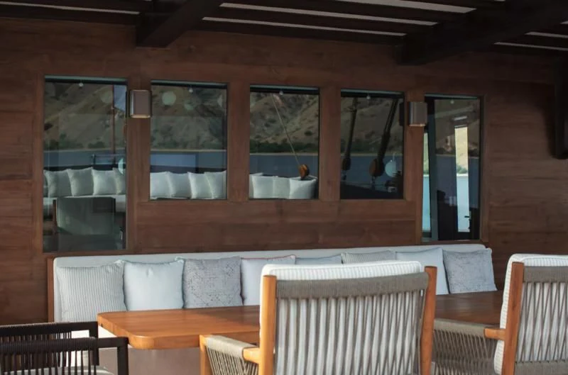 a room with chairs and tables aboard VELA Yacht for Charter