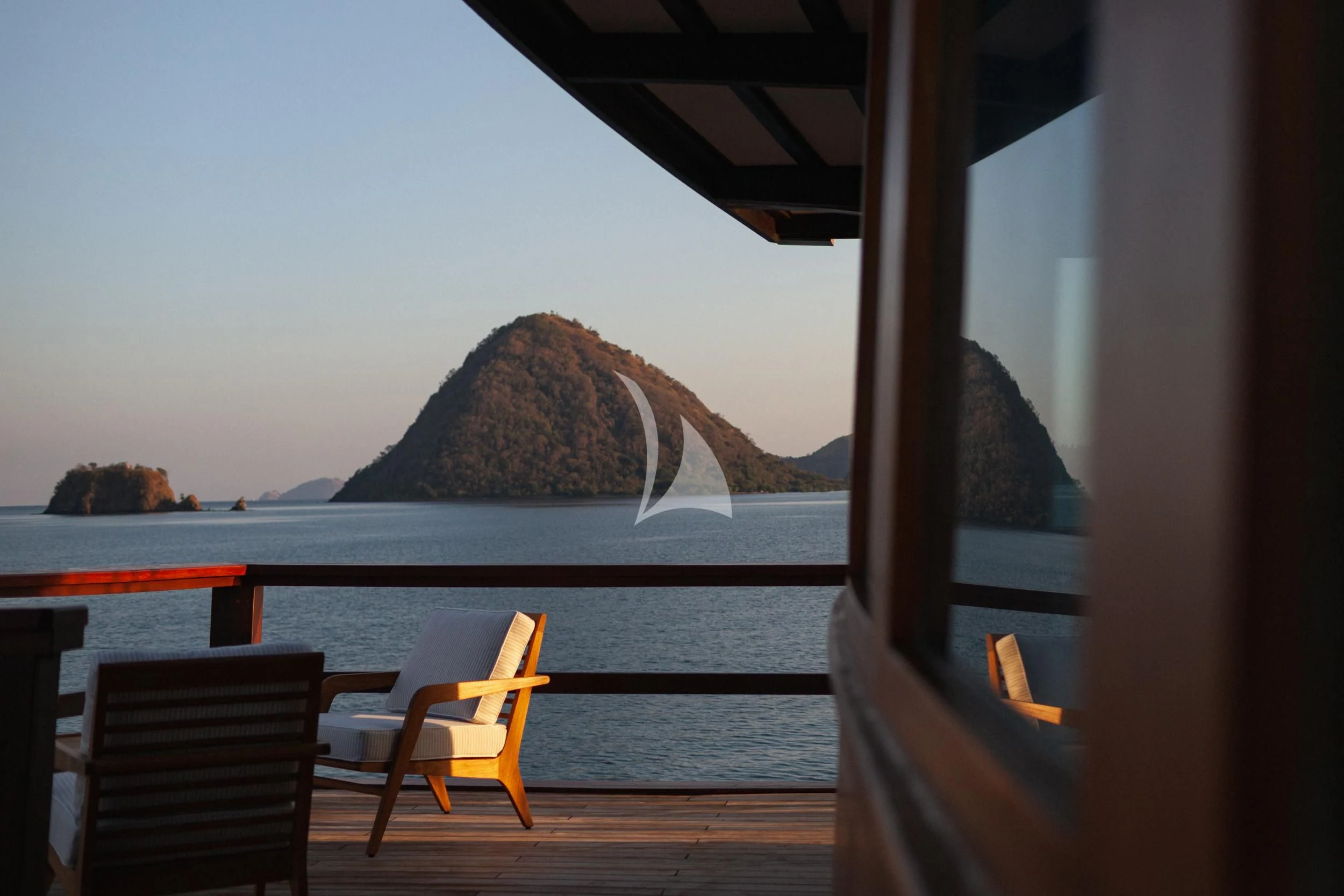 a view of a mountain from a deck of a boat aboard VELA Yacht for Charter