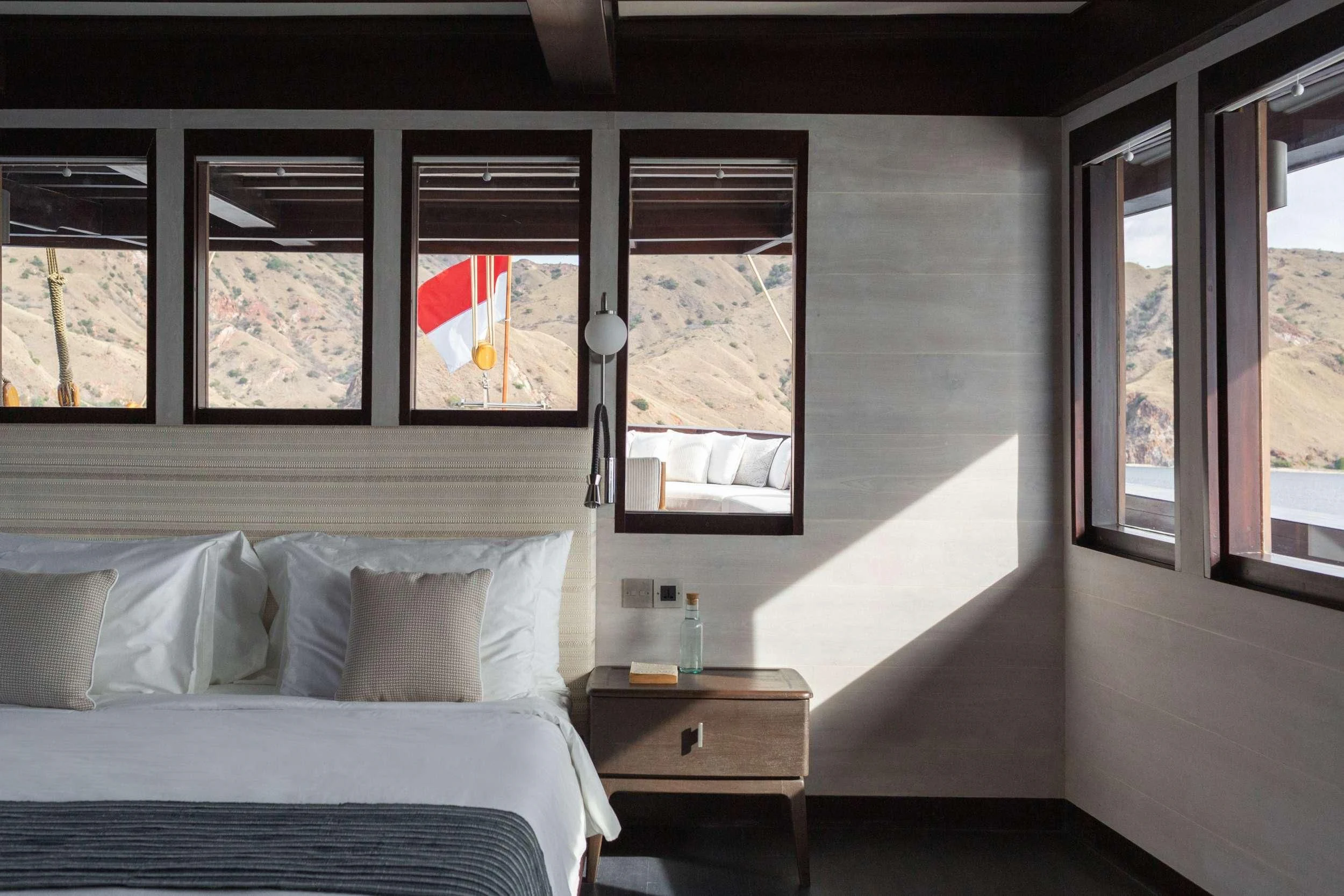 a room with a bed and a window aboard VELA Yacht for Charter