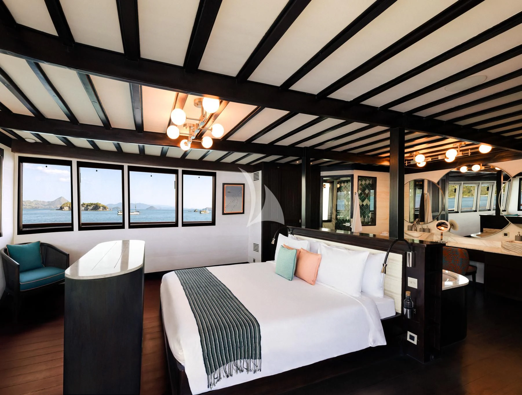 a room with a bed and a desk aboard VELA Yacht for Charter