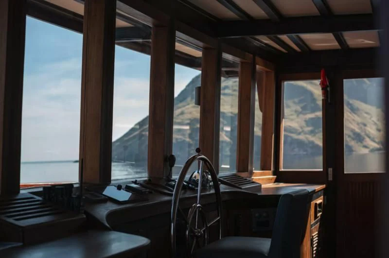a room with a large window and a desk with a computer on it aboard VELA Yacht for Charter