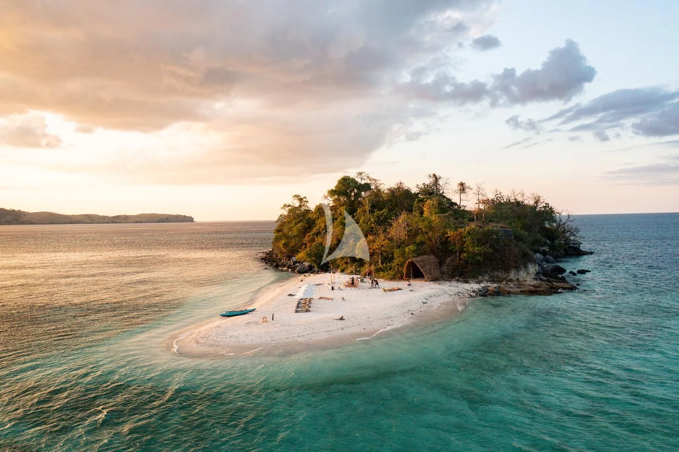 a beach with a rock structure on it aboard VELA Yacht for Charter