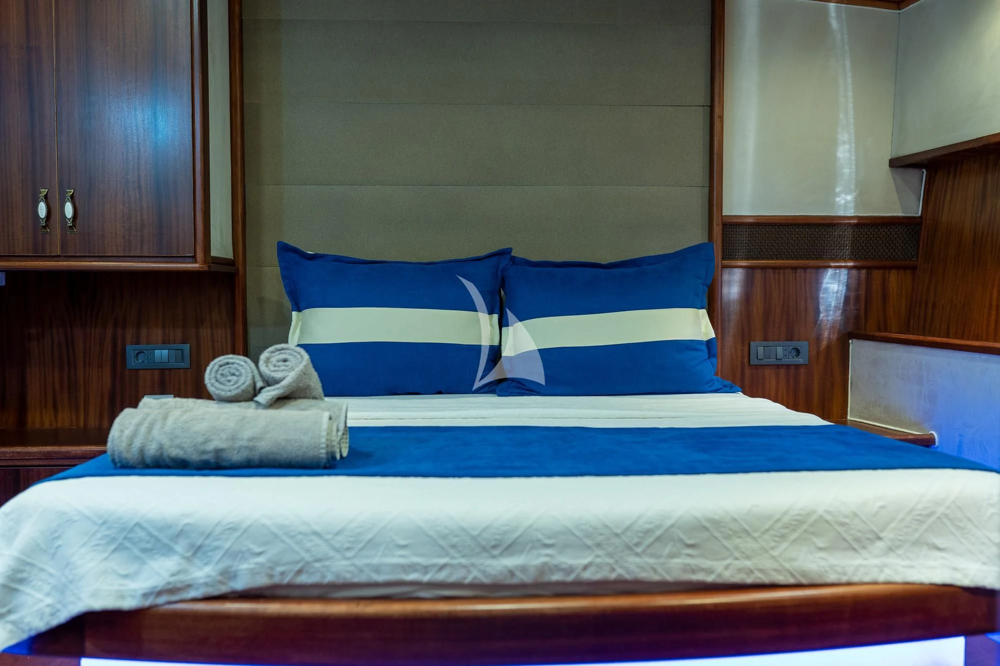 a bed with blue and white pillows aboard NEVRA QUEEN Yacht for Sale