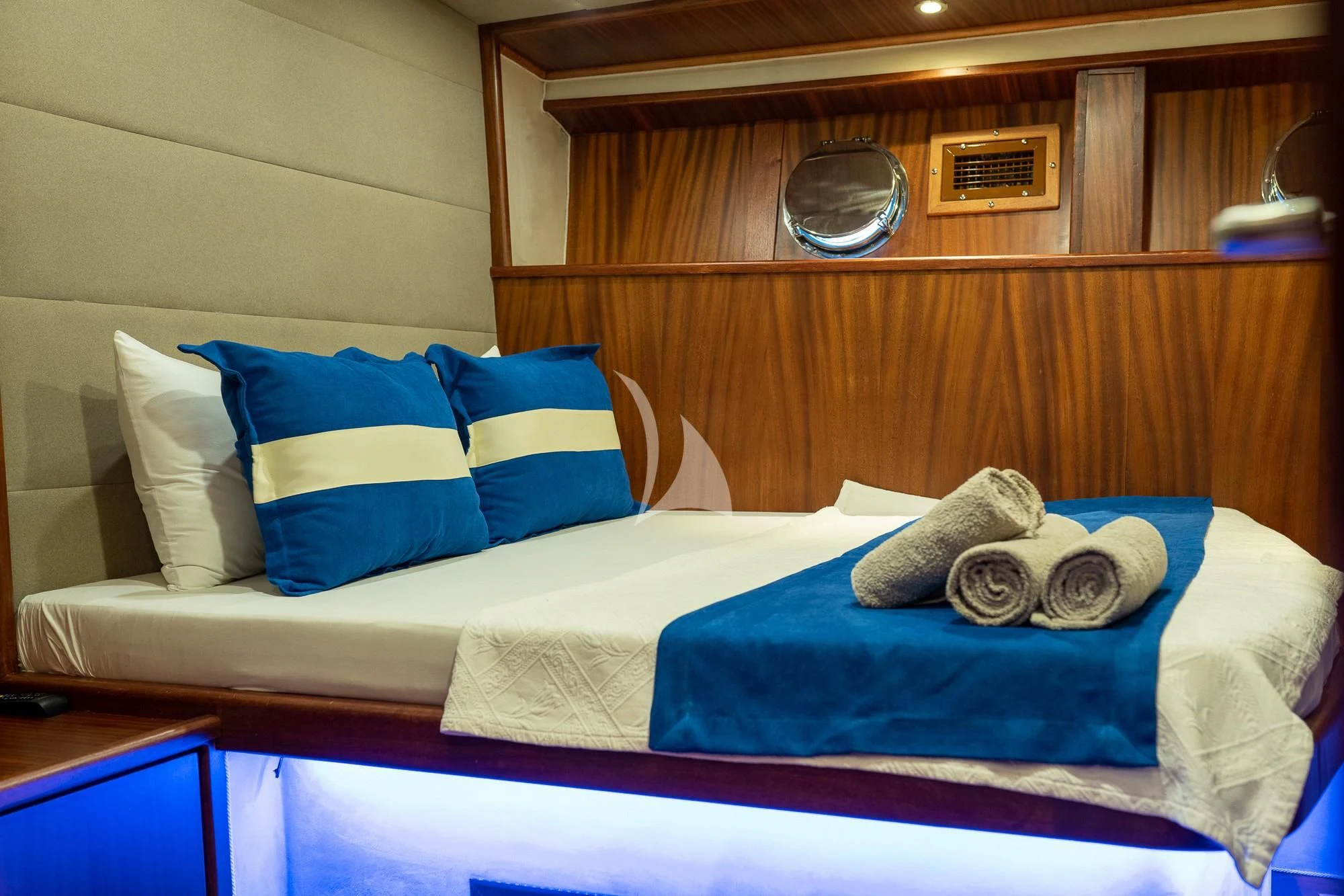 a bed with blue pillows aboard NEVRA QUEEN Yacht for Sale