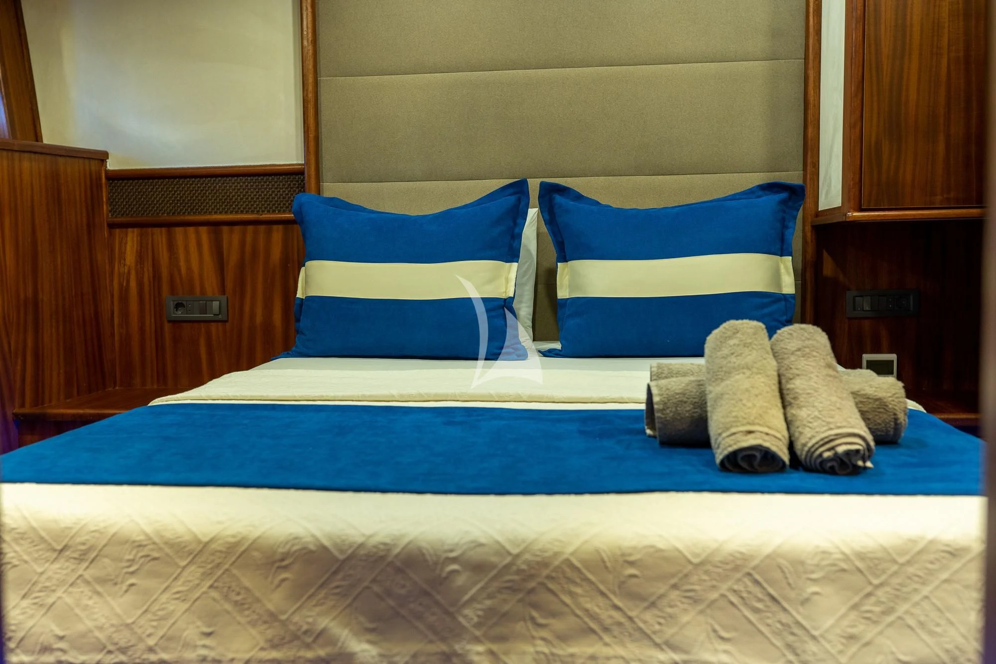 a bed with blue and white pillows aboard NEVRA QUEEN Yacht for Sale