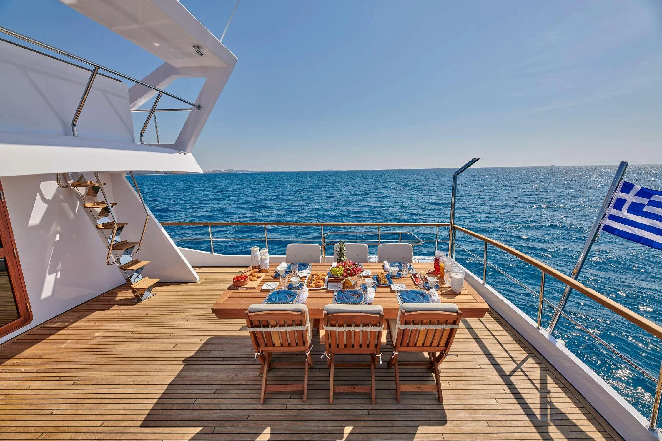 a deck with a table and chairs on it aboard WIDE LIBERTY Yacht for Sale