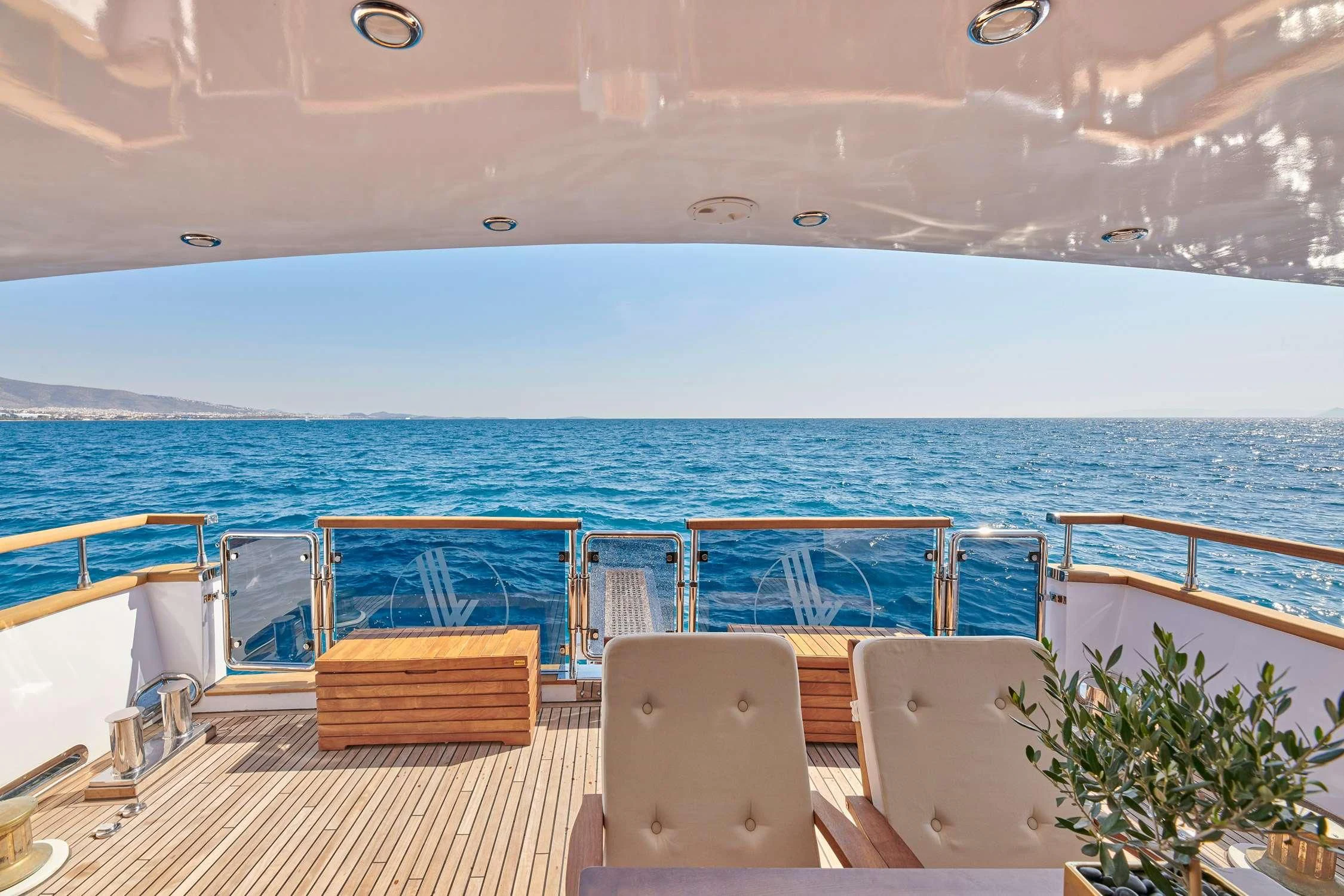 a deck with chairs and a body of water in the background aboard WIDE LIBERTY Yacht for Sale