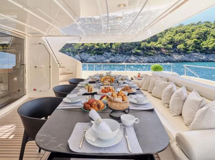 a dining table with a view of the ocean and the ocean aboard SEVEN S Yacht for Charter