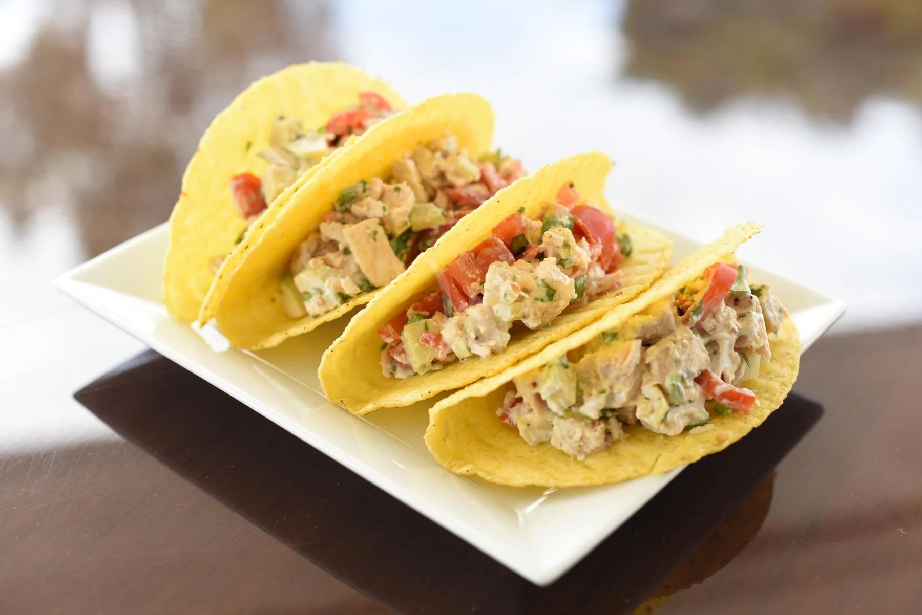 a hot dog with lettuce and tomato on a wooden table aboard SEVEN S Yacht for Charter