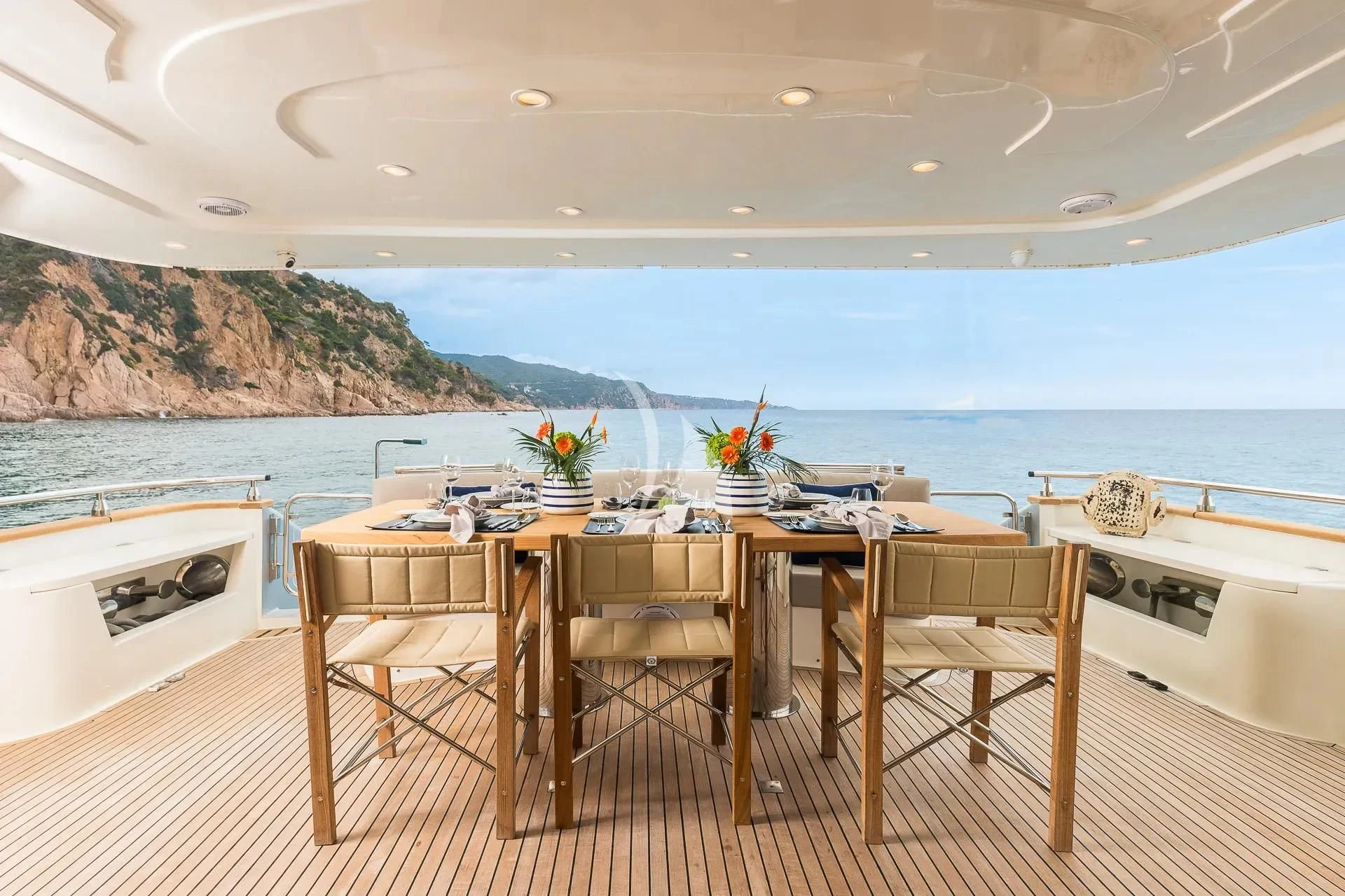 a table and chairs on a deck overlooking a body of water aboard KIAWAH II Yacht for Sale