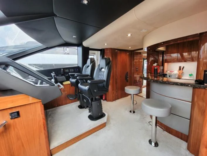 a room with a table and stools and a large window aboard MY LILY Yacht for Sale