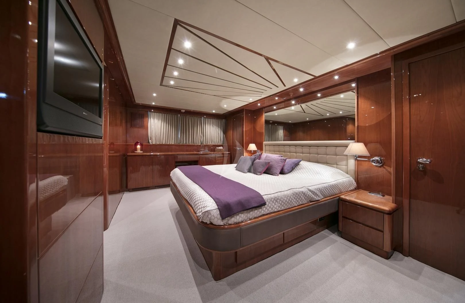 a bedroom with a bed and a television aboard YLANG YLANG Yacht for Sale