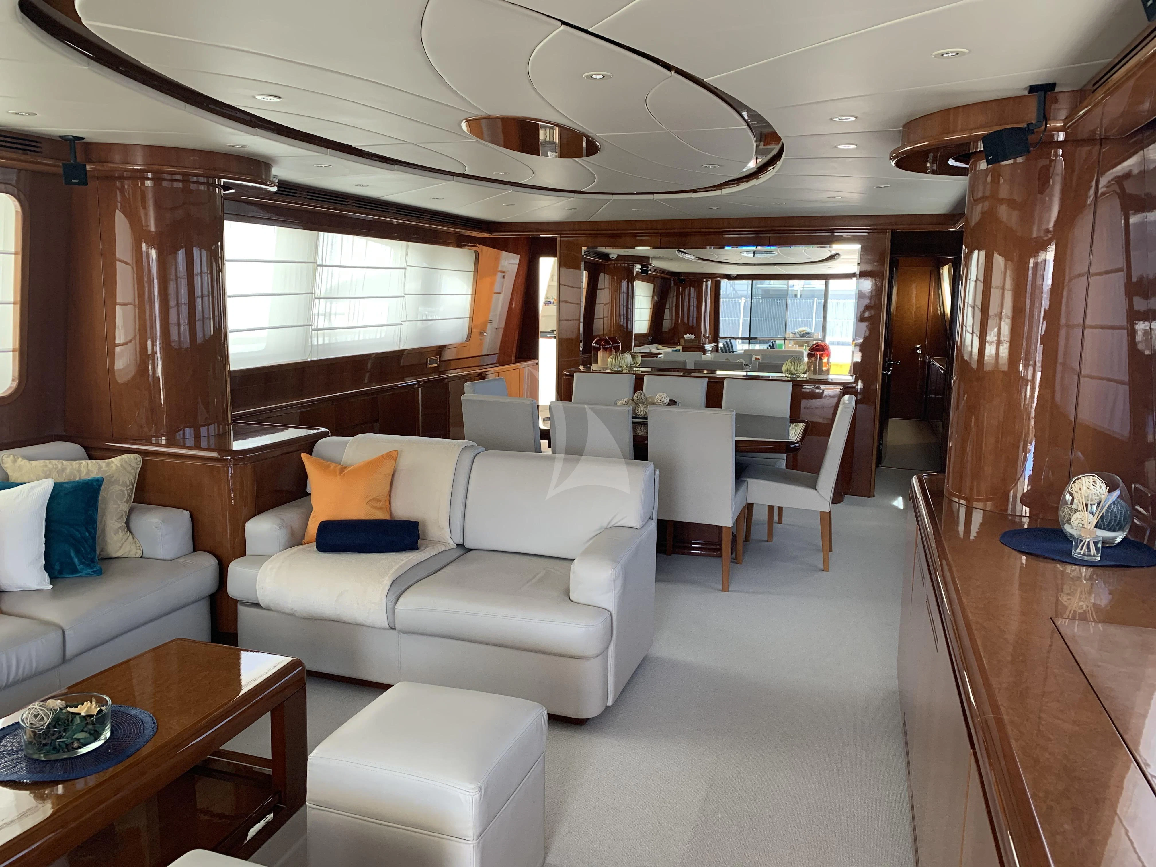 a living room with a couch and a table aboard YLANG YLANG Yacht for Sale