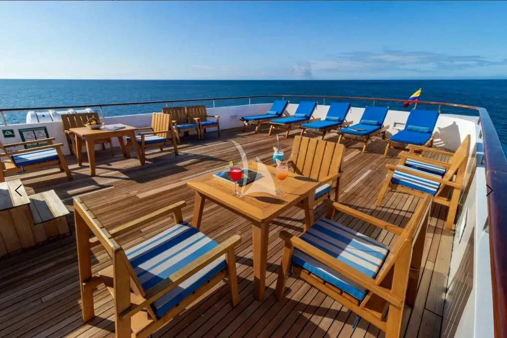 a deck with chairs and tables on it by the water aboard M/Y PASSION Yacht for Sale