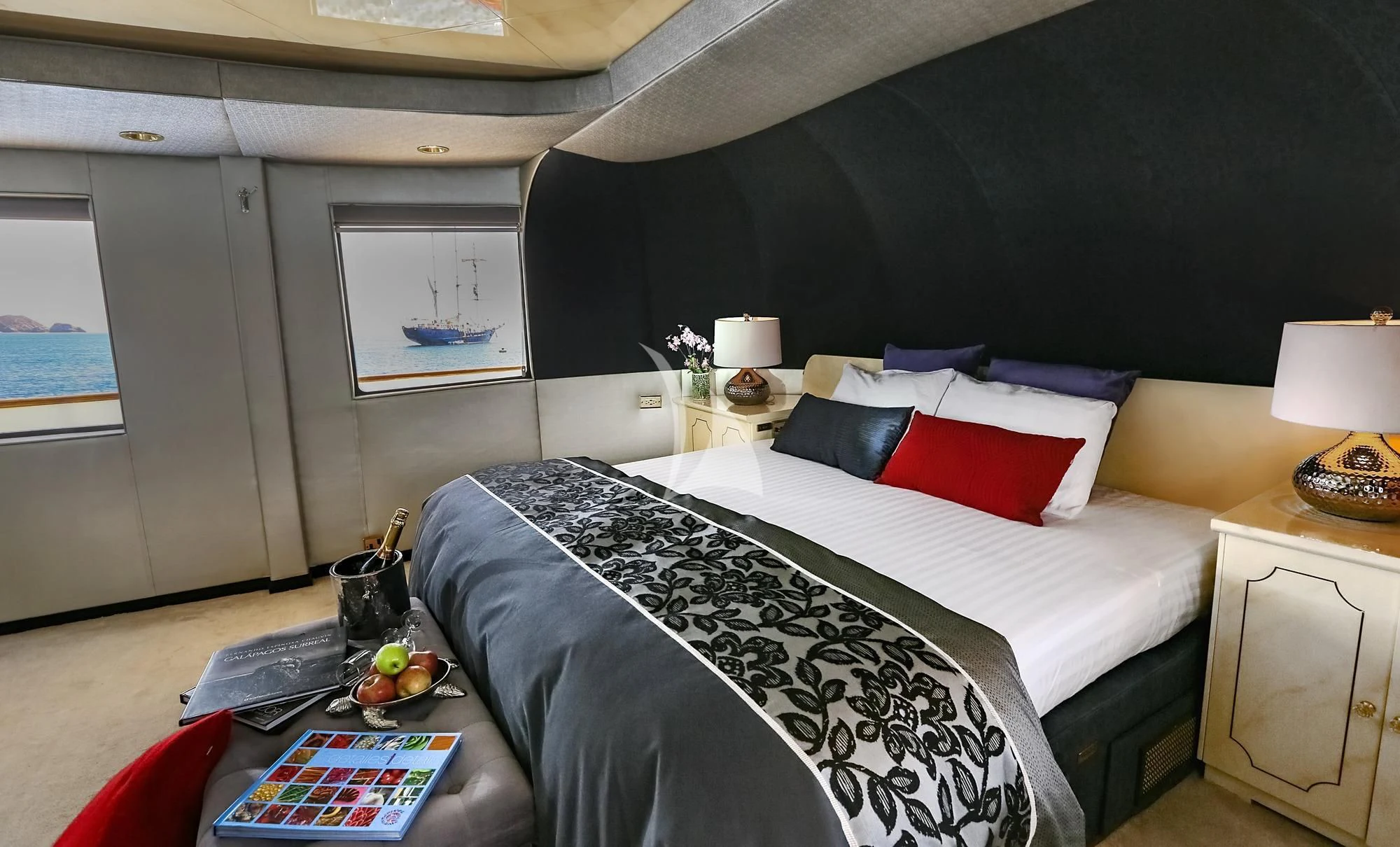 a bed with a black and white bed spread and red pillows aboard M/Y PASSION Yacht for Sale