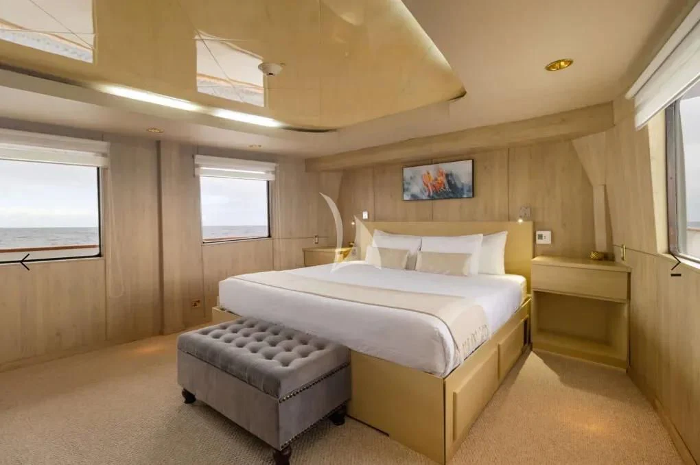 a room with a bed and a chair aboard M/Y PASSION Yacht for Sale