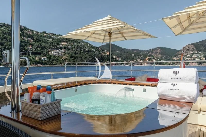 a pool with a couple of umbrellas and a basket of food aboard W EXPLORER Yacht for Sale