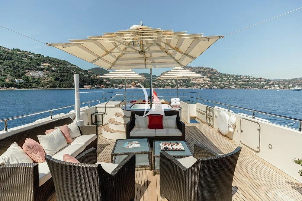 a deck with chairs and an umbrella aboard W EXPLORER Yacht for Sale