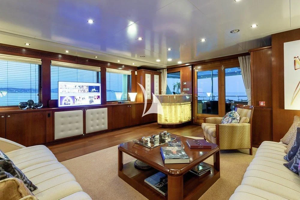 a living room with a table and couches aboard W EXPLORER Yacht for Sale