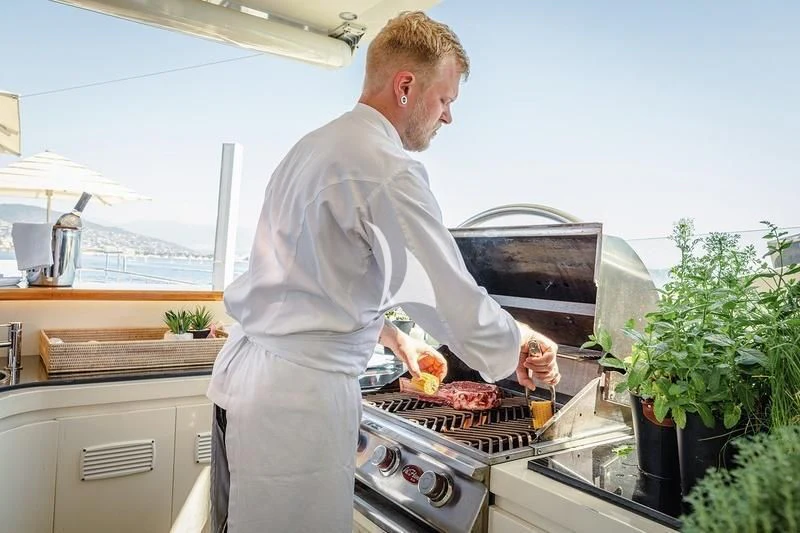 a chef preparing food in a kitchen aboard W EXPLORER Yacht for Sale
