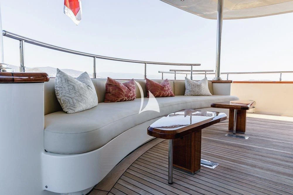 a couch with pillows and a coffee table in a room with a window aboard W EXPLORER Yacht for Sale