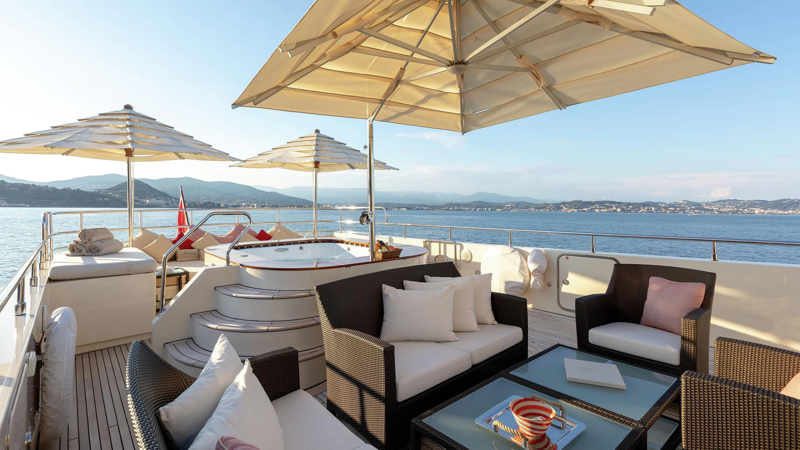 a large patio with a table and chairs and umbrellas aboard W EXPLORER Yacht for Sale