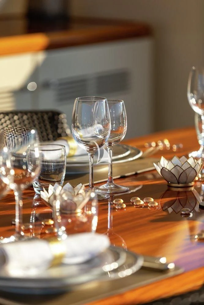 a table with wine glasses and food aboard W EXPLORER Yacht for Sale