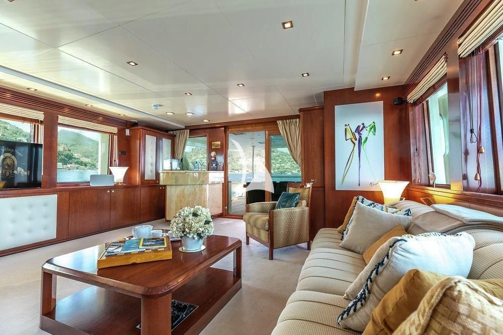 a living room with a table and couches aboard W EXPLORER Yacht for Sale
