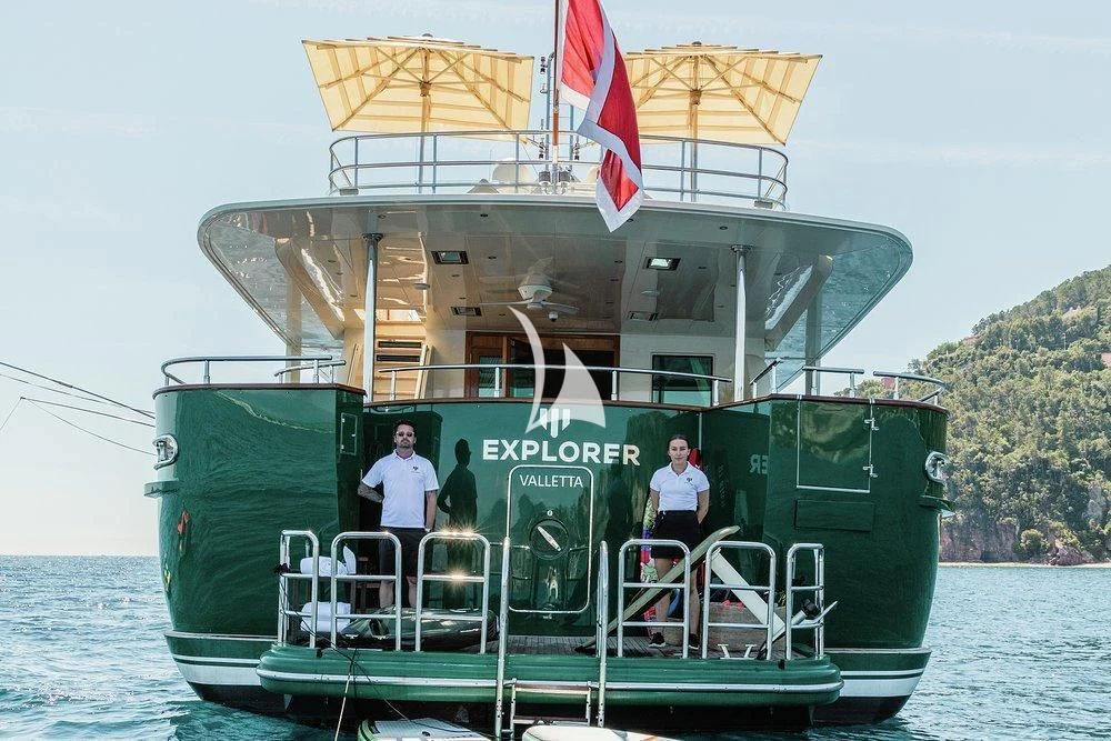 a large green boat with a flag on it aboard W EXPLORER Yacht for Sale