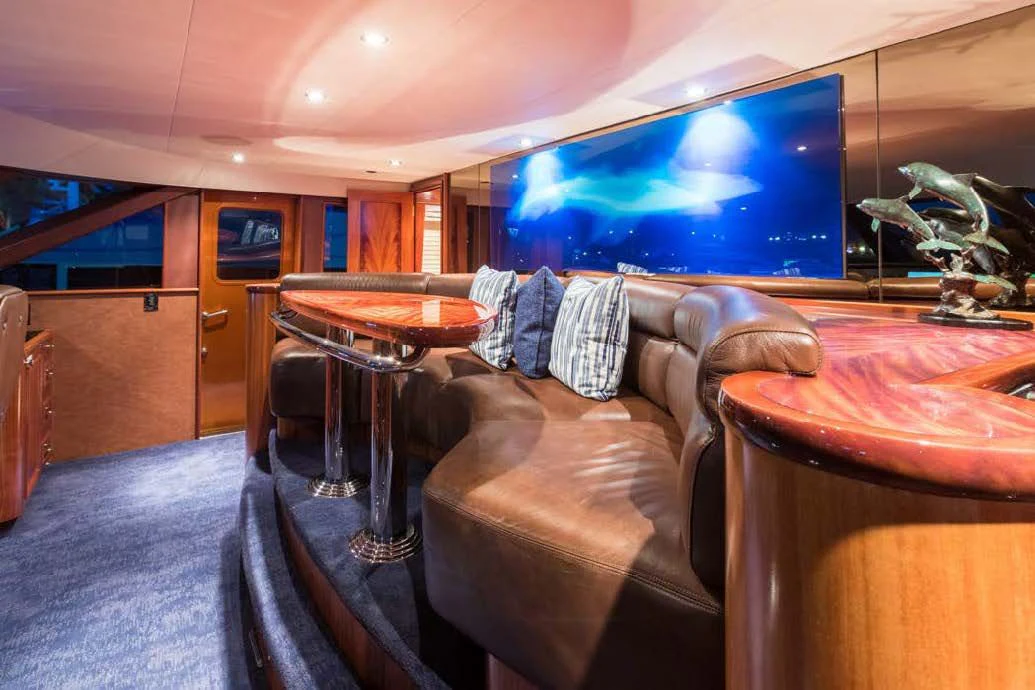 a person lying on a couch in a room with a tv on the wall aboard TRUST FUN Yacht for Sale