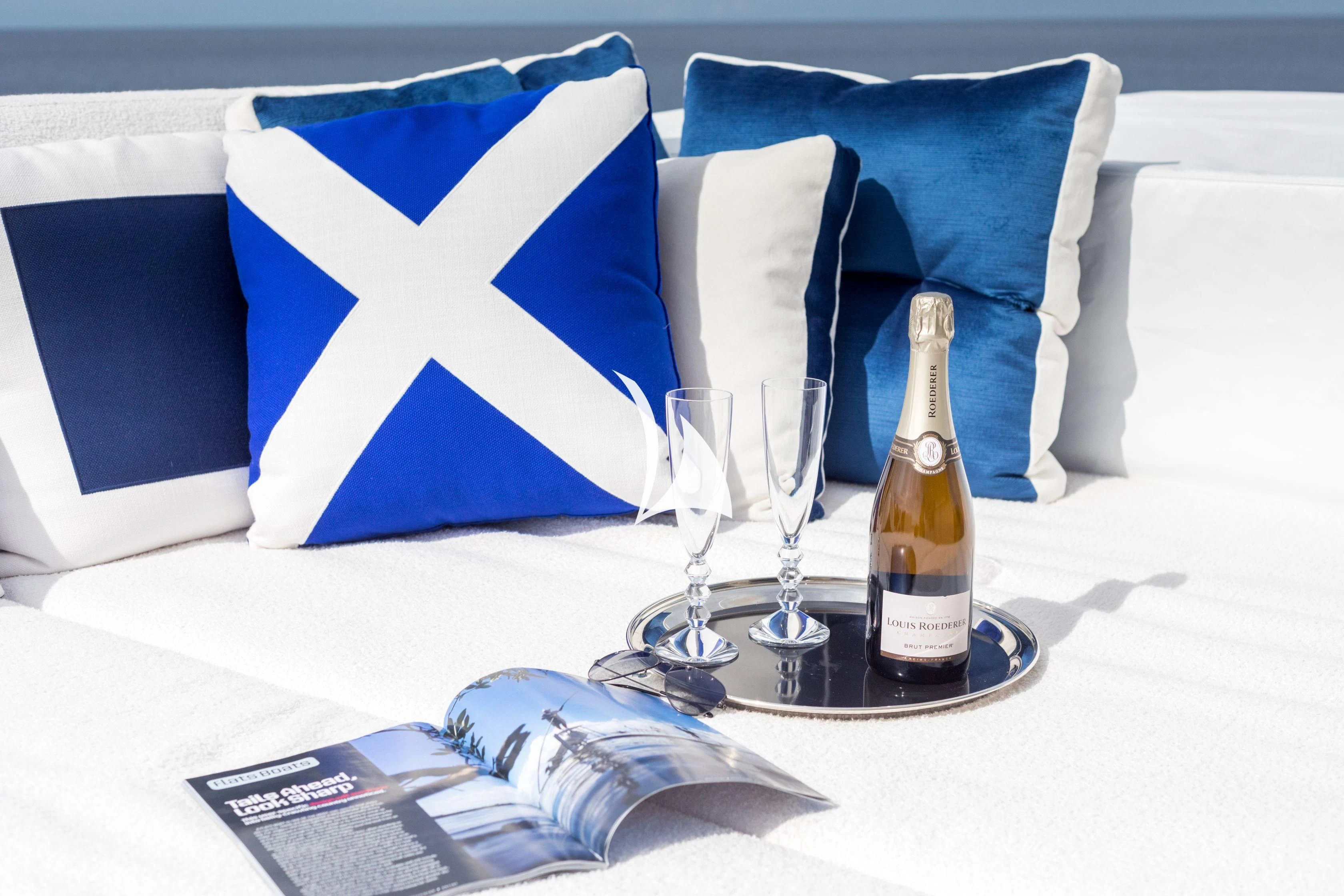 a bottle of champagne and a glass on a table aboard TRUST FUN Yacht for Sale