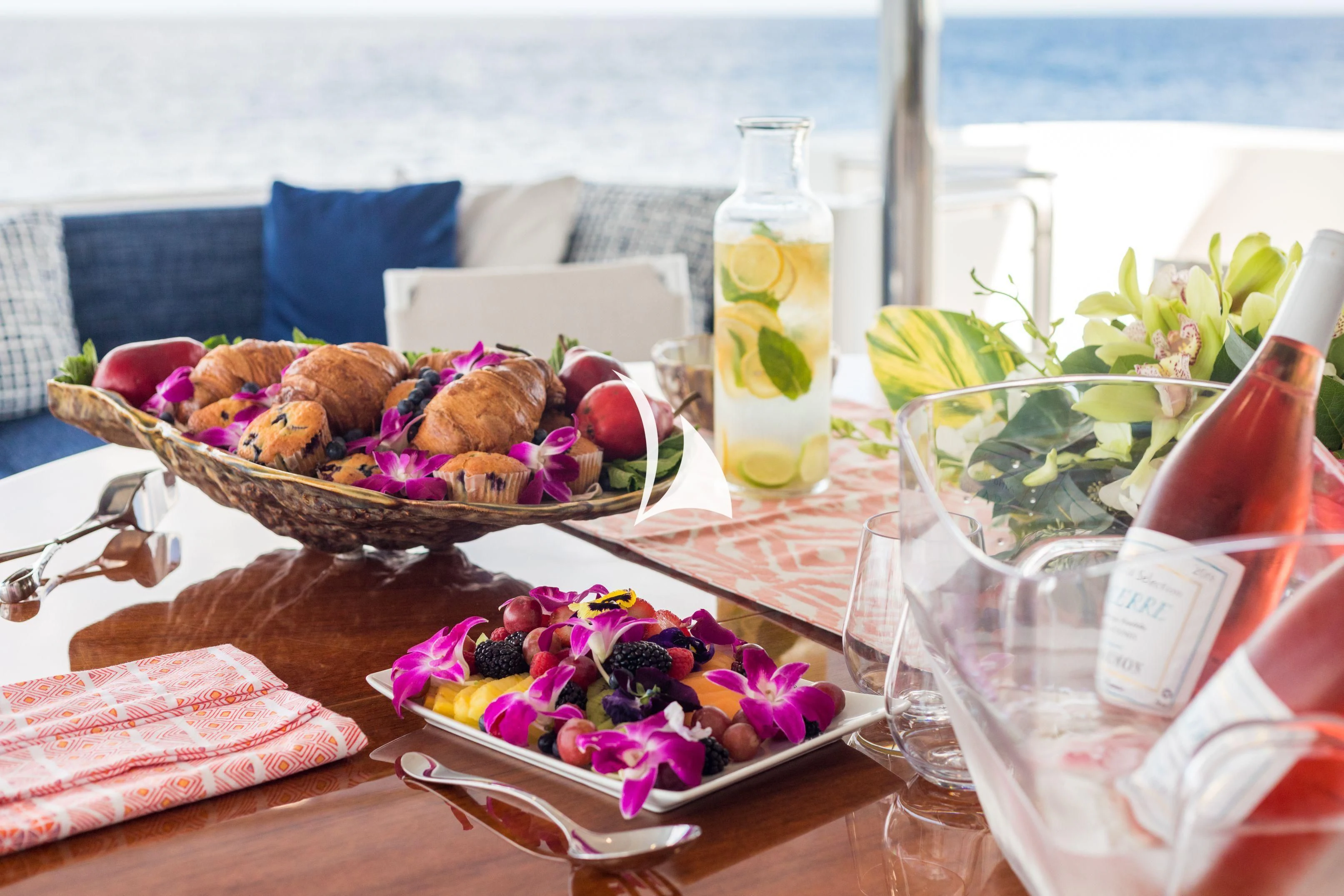 a table with a basket of food and a bottle of water aboard TRUST FUN Yacht for Sale