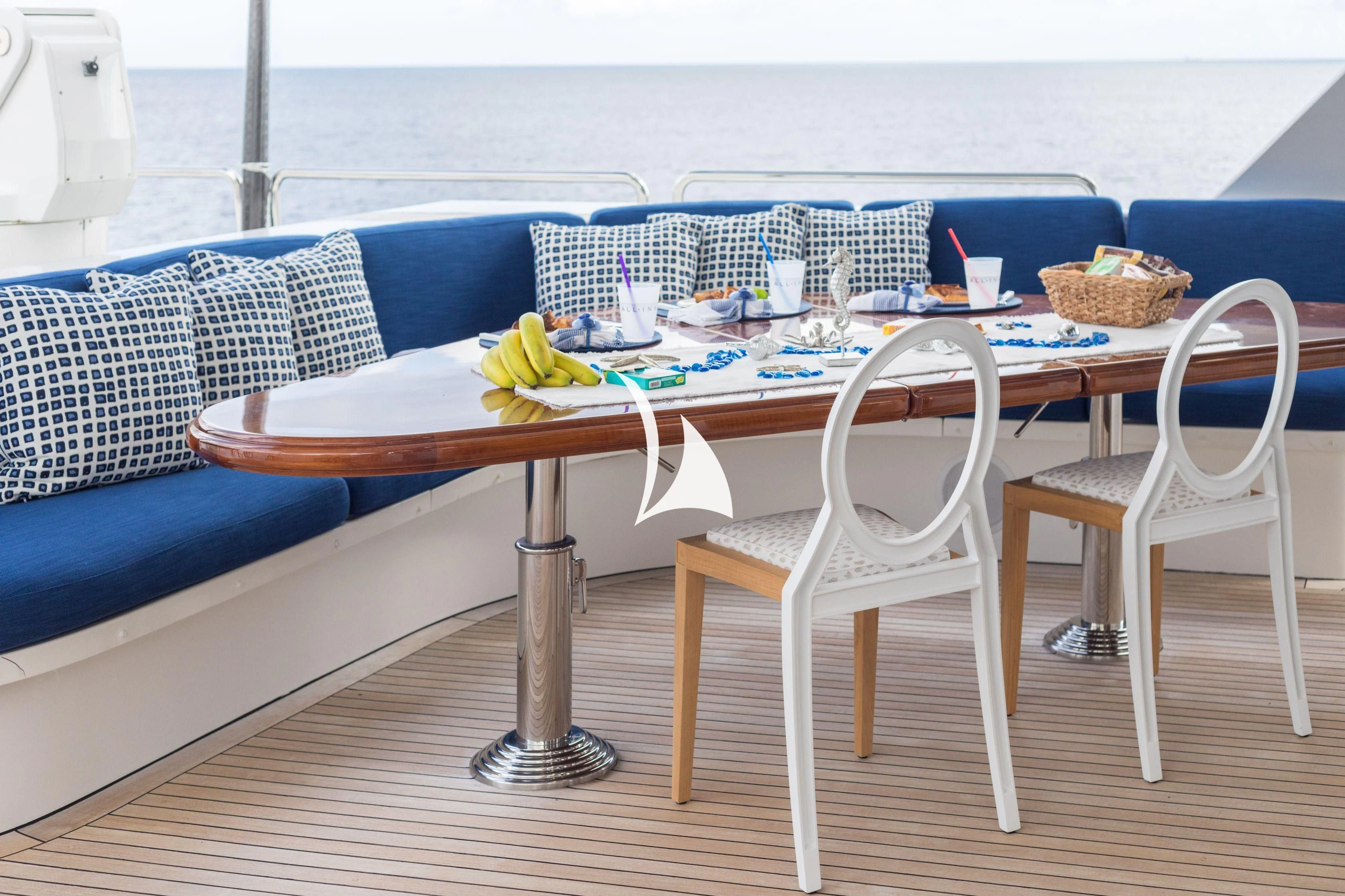 a table with a couple chairs and a couch in the background aboard TRUST FUN Yacht for Sale