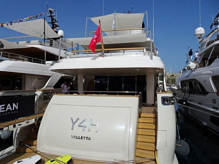 a boat with a flag on the deck aboard Y4H Yacht for Sale