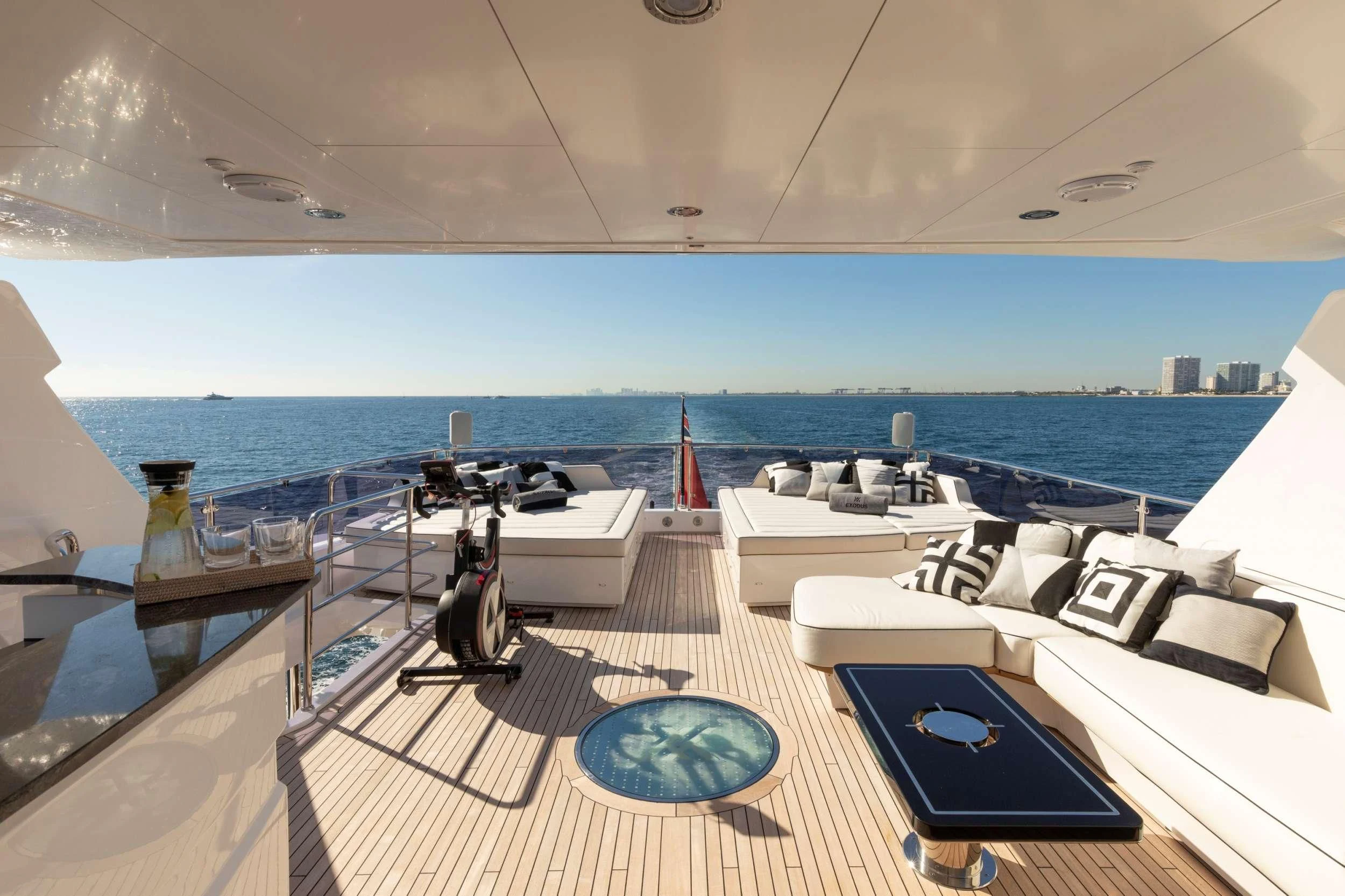 a lounge area with a pool and a large body of water in the background aboard NEXUS Yacht for Charter
