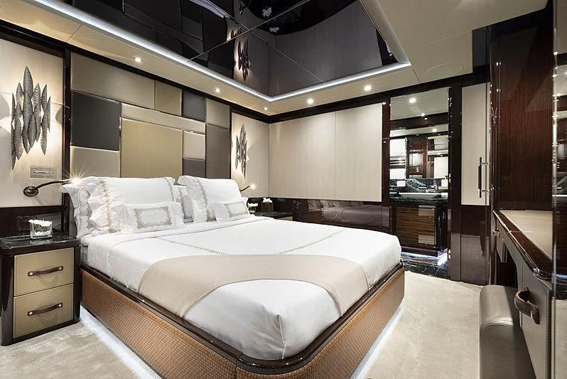 a bedroom with a bed and a mirror aboard NEXUS Yacht for Charter