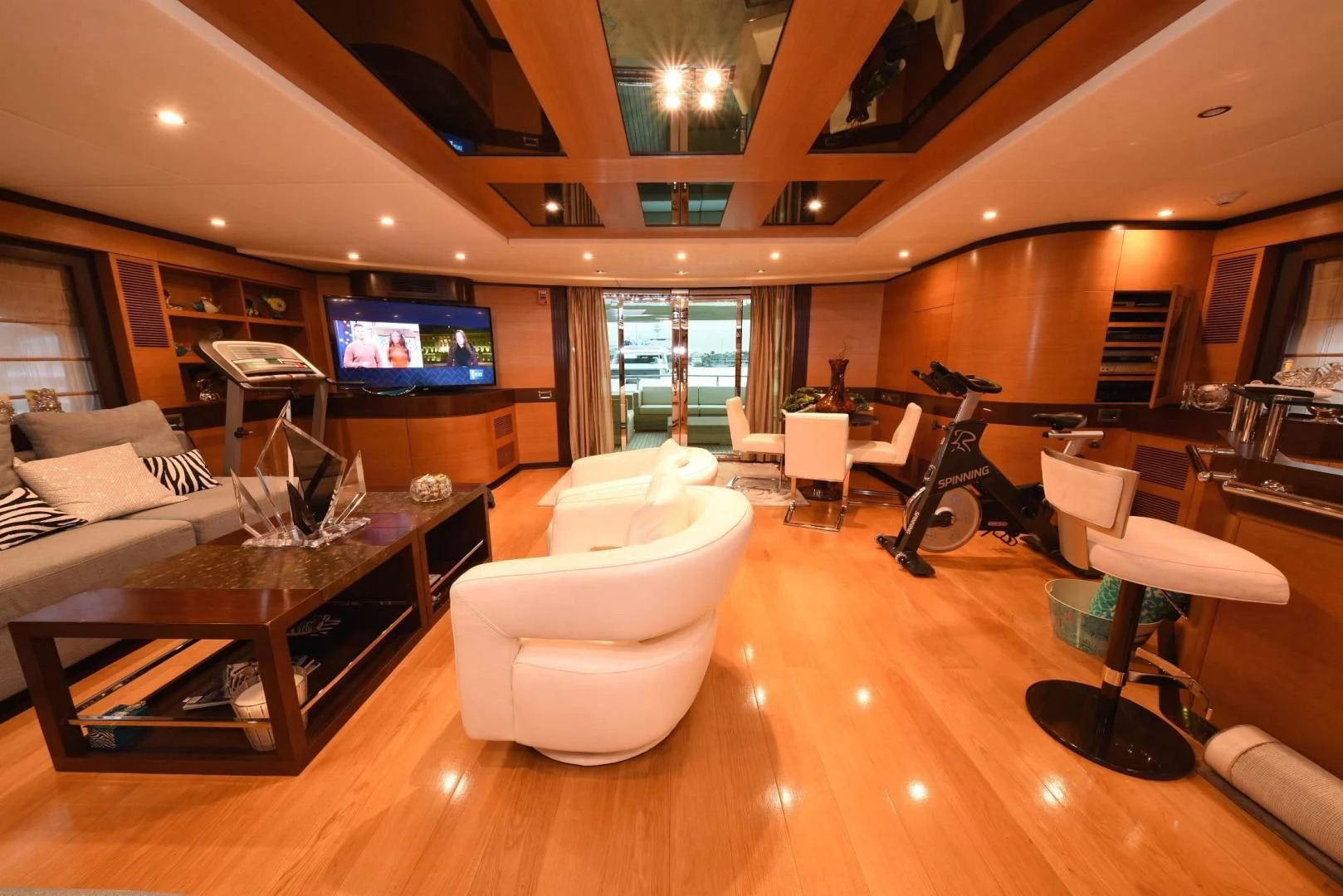 a room with a large television and a table with chairs aboard KIMBERLIE Yacht for Sale