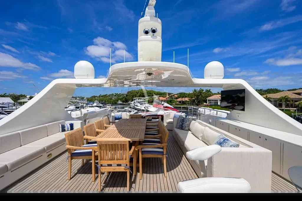 a deck with chairs and a table on it aboard KIMBERLIE Yacht for Sale