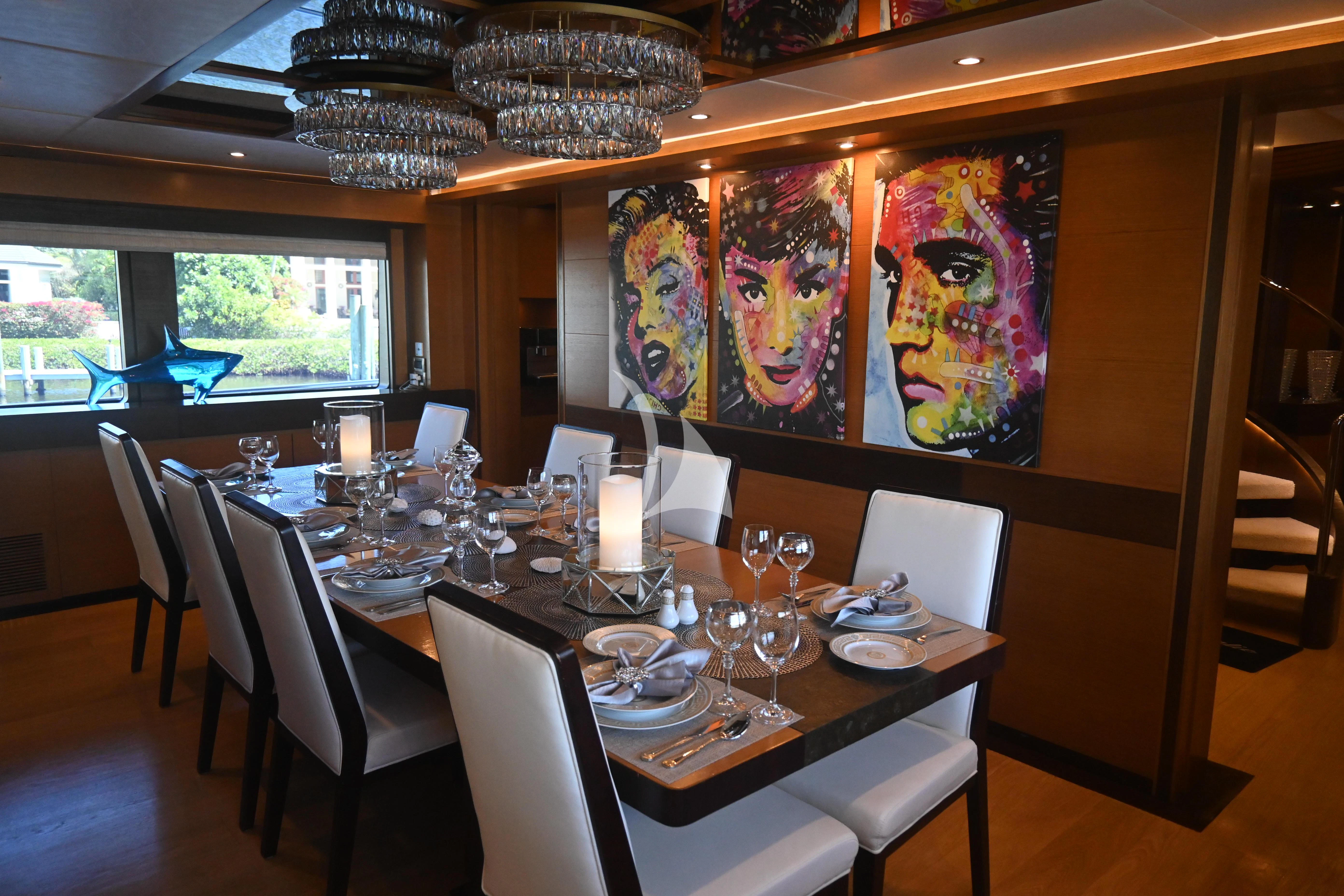 a dining room table with a large painting on the wall aboard KIMBERLIE Yacht for Sale